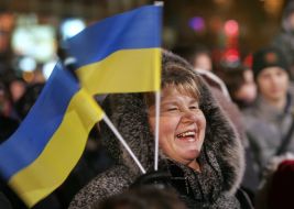 Жінка тримає в руках прапорці