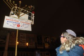 The boy reads the label on the greeting with Hanukkah