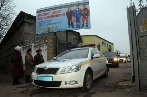 A car drives out from the gate of colony