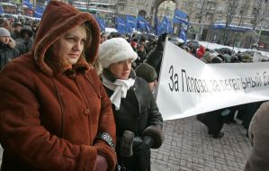 The participants of the mass meeting hold a placard