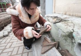 A woman holds the fragment of ancient tableware