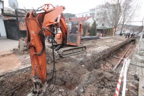 A worker sits in an excavator cab