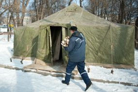 Сотрудник МЧС несет дрова