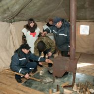 Сотрудник МЧС подбрасывает дрова в печь