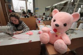 Workwoman on the factory of soft toys