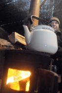Мужчина греется у "буржуйки"