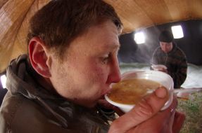 Мужчина ест суп