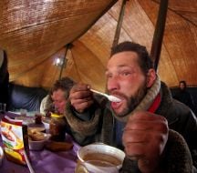 Мужчина ест суп