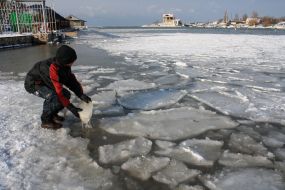 A boy reaches ice from water