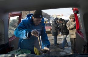 A man pours hot tea in glass
