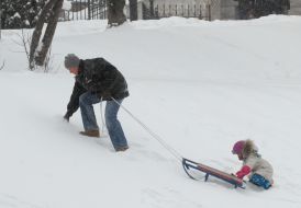 Мужчина с ребенком катаются на санках