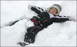 Мальчик лежит в снегу