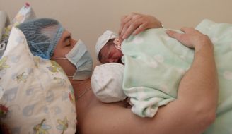 A young father with babies in the postnatal ward