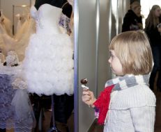 A little girl examines wedding-dresses