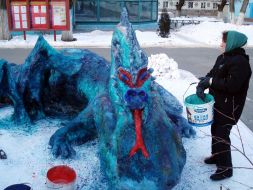 A prisoner stands near the snow sculpture of dragon