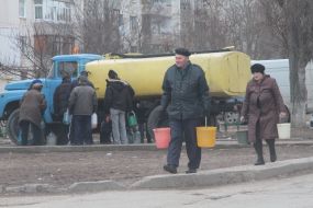 A man carries buckets with water