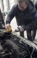 The participant of action washes the engine of car by carbonated water