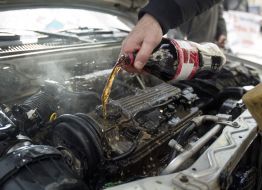 The participant of action washes the engine of car by carbonated water