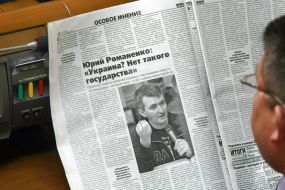 A folk deputy reads a newspaper