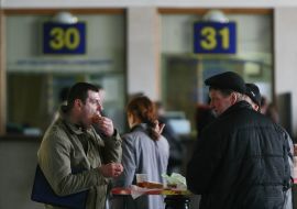 Чоловік їсть біля залізничних кас