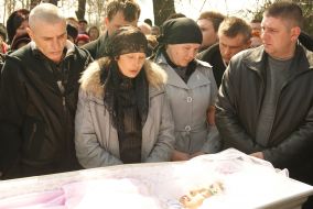 Tatyana Surovitskaya and Aleksey Surovitskiy near the coffin of Oksana Makar