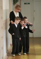 Воспитательница ведет слепых детей по коридору