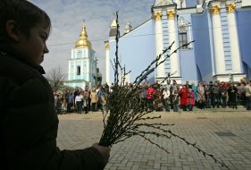 A boy holds willow branches