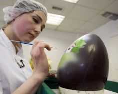Кондитер расписывает пасхальное яйцо из шоколада