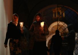 Віруючі несуть запалені свічки додому