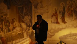 Віруючий несе запалену свічку додому