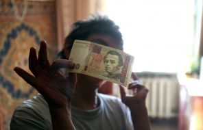 Irina Pleshko holding a 100-hryvnia banknote