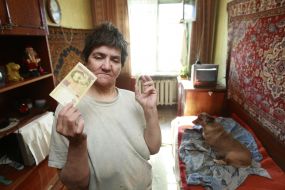 Irina Pleshko holding a 100-hryvnia banknote