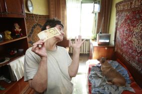 Irina Pleshko holding a 100-hryvnia banknote