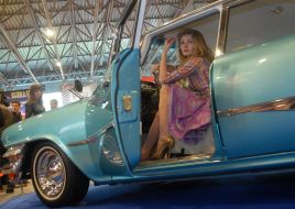 A girl sits after the helm of retro-car