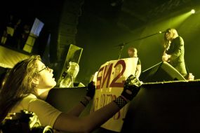 The girl holds a placard during a concert