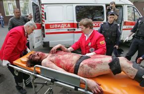 Медицинские работники транспортируют на носилках участника акции протеста