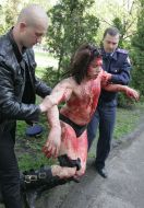 Участника акции протеста ведут к автомобилю скорой помощи