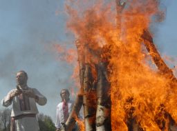 Men stand near a fire