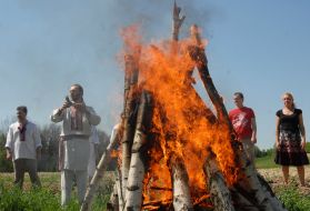 Мужчины стоят возле костра