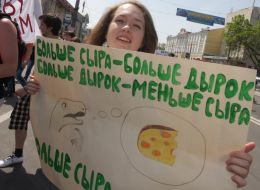 Участница монстрации держит плакат