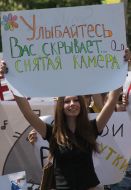 Участница монстрации держит плакат