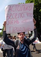 Участник монстрации несет плакат