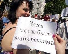 Участница монстрации держит плакат