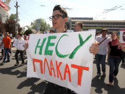 Участник монстрации несет плакат