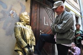 A man stands near the head of Stalin