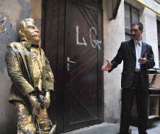 A man stands near the head of Stalin
