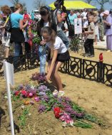 Местные жители возлагают цветы к могиле