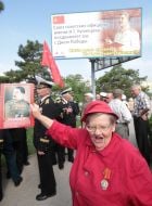 Еlderly woman holds the portrait of Stalin