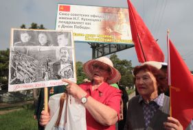Elderly women hold a placard