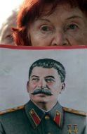 Еlderly woman holds the portrait of Stalin